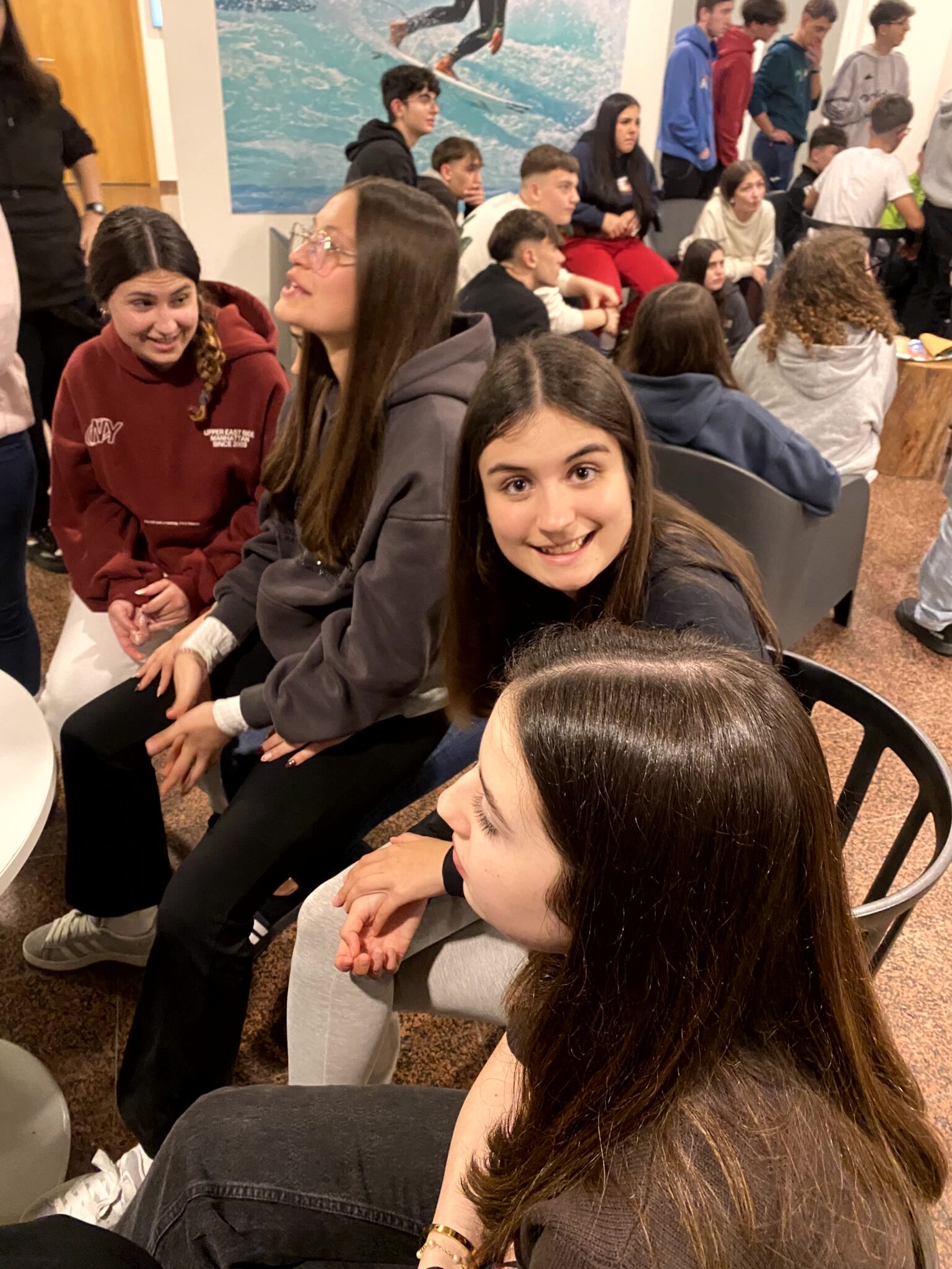 Dentro de un grupo de adolescentes una de ella mira a cámara y sonríe
