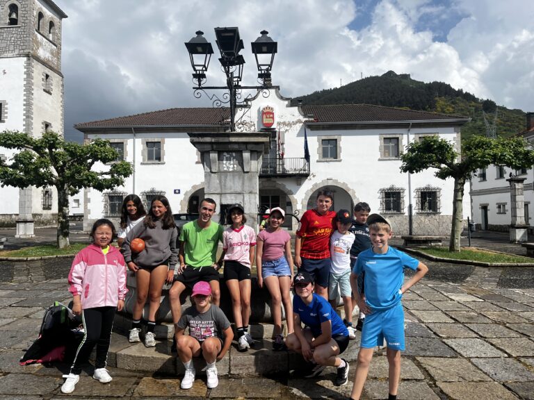 grupo de primaria con su monitor posando en la plaza de un pueblo de leon