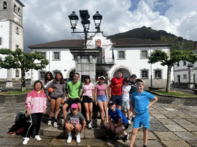 grupo de primaria con su monitor posando en la plaza de un pueblo de leon