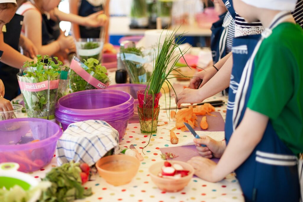 mesa con ingredientes y niños cocinando
