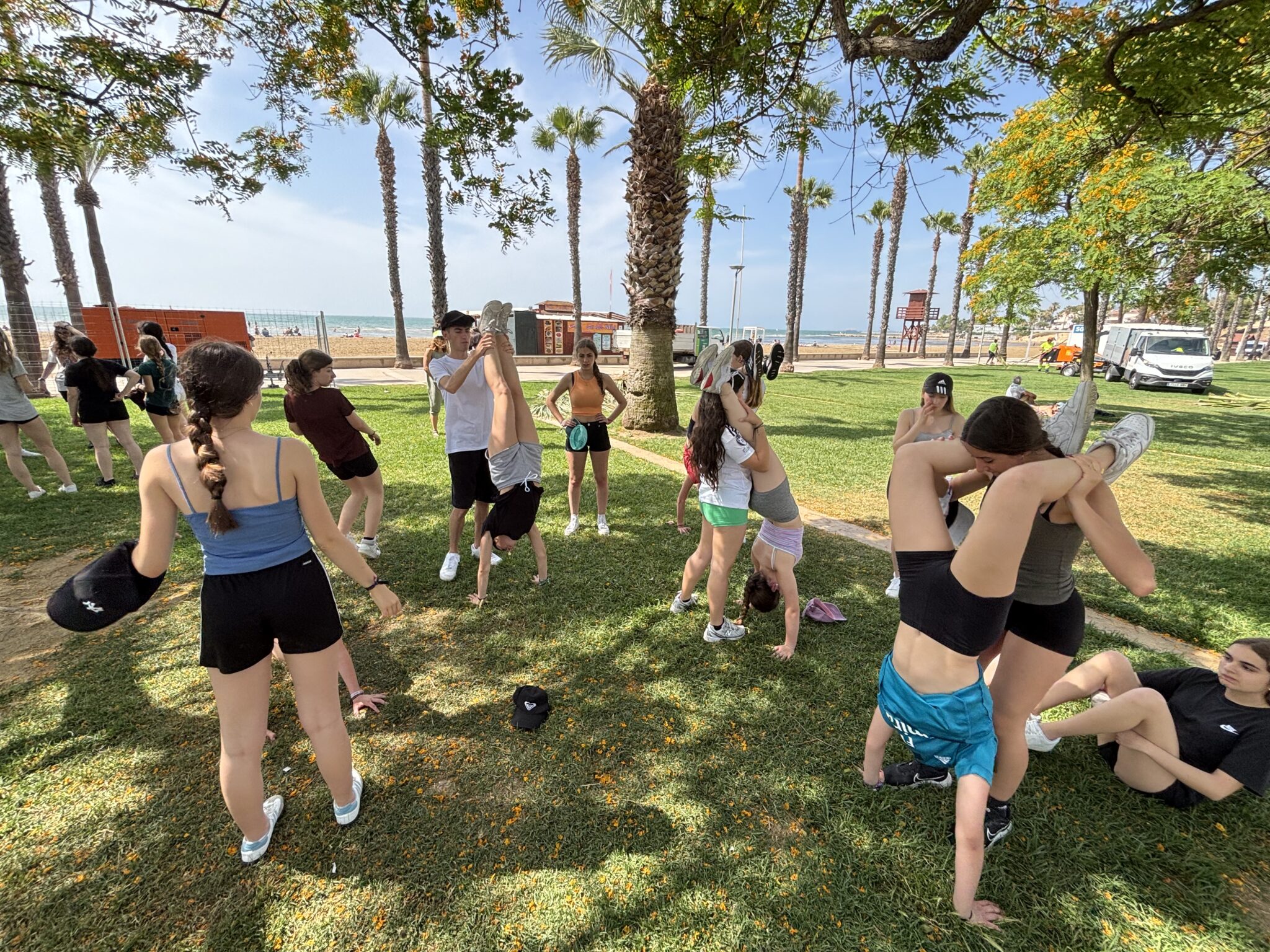 Grupo de secundaria jugando por parejas en una parque junto a la playa