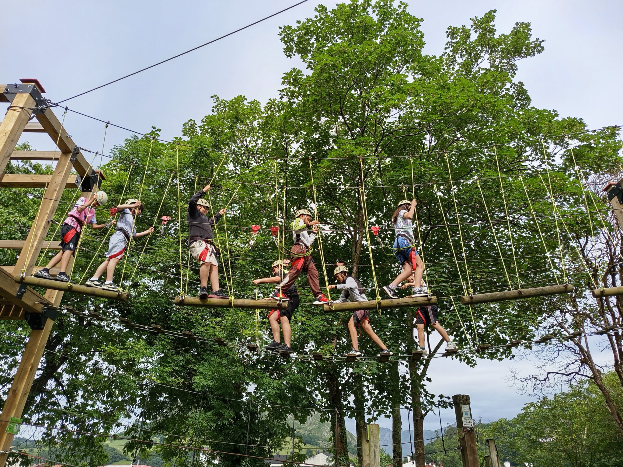 parque de aventuras con chavales pasando por los troncos