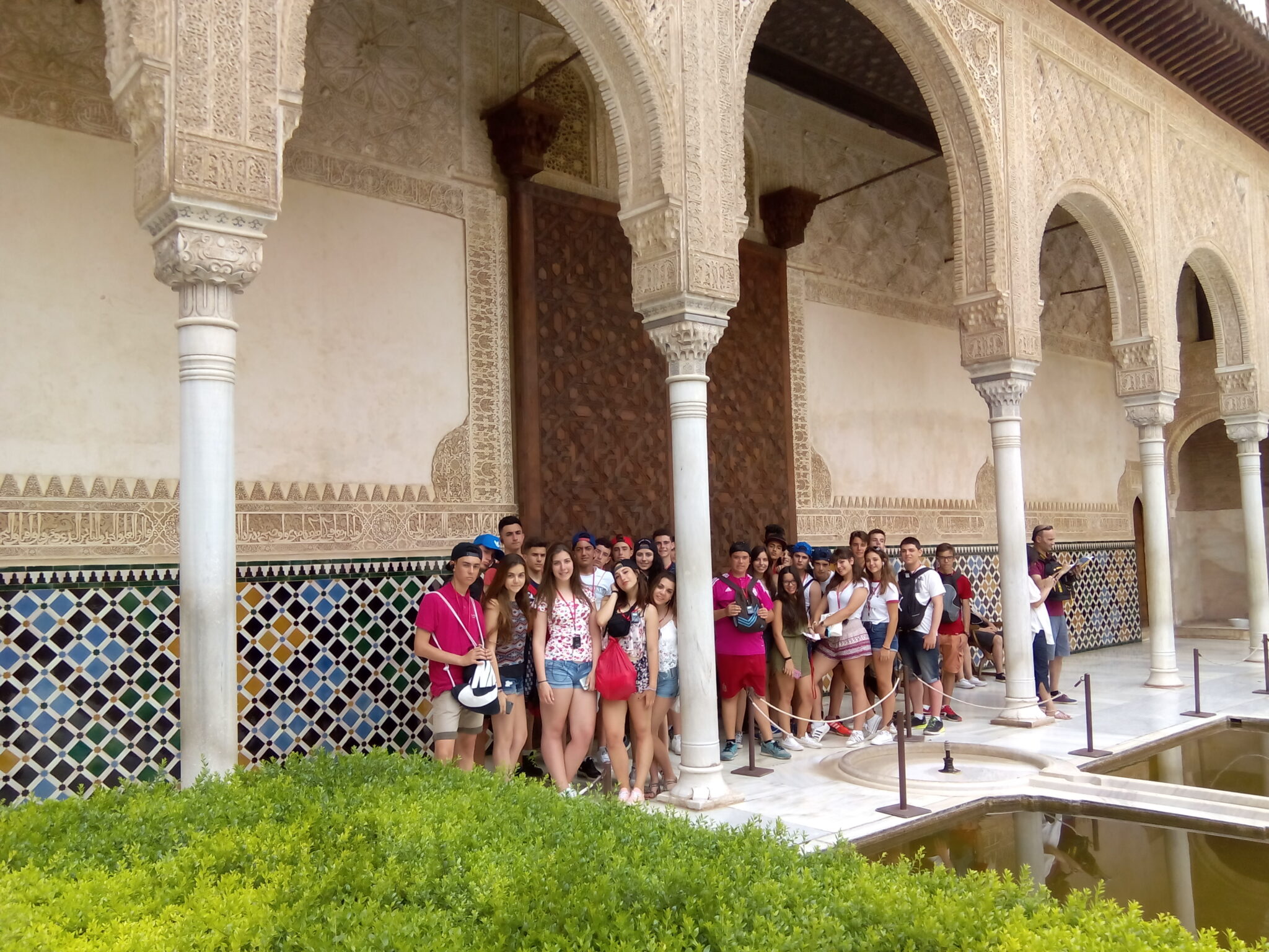 Grupo de chavales de secundaria en bajo los arcos de un patio de La Alhambra