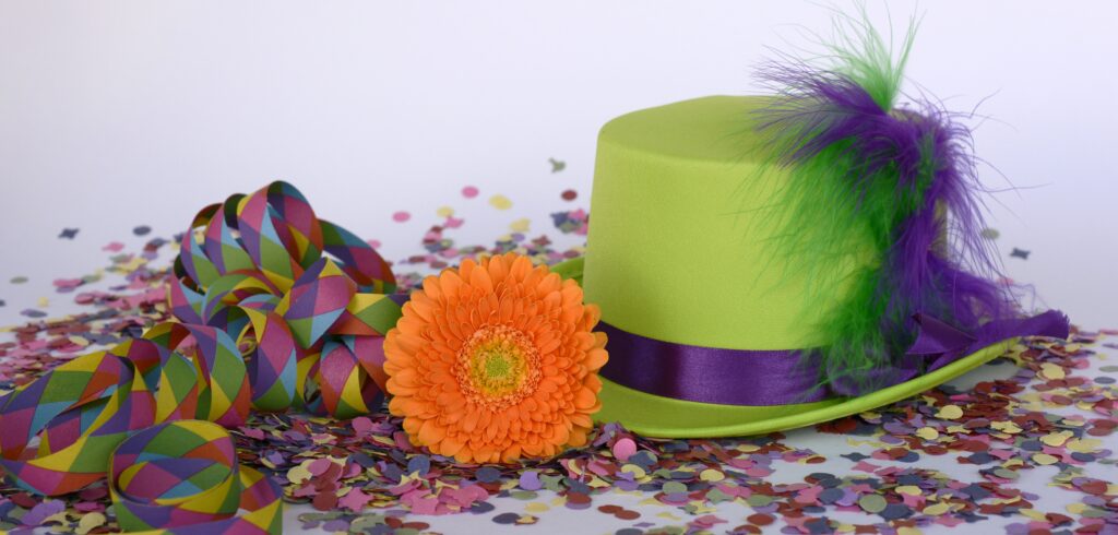 chistera verde con lazo morado y flor naranja con confeti