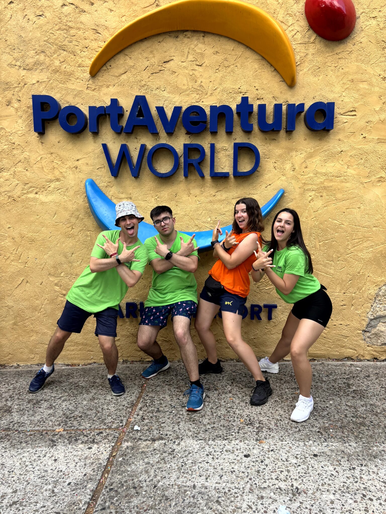 grupos de monitores y coordinadora con la camiseta corporativa debajo del logo de PortAventura