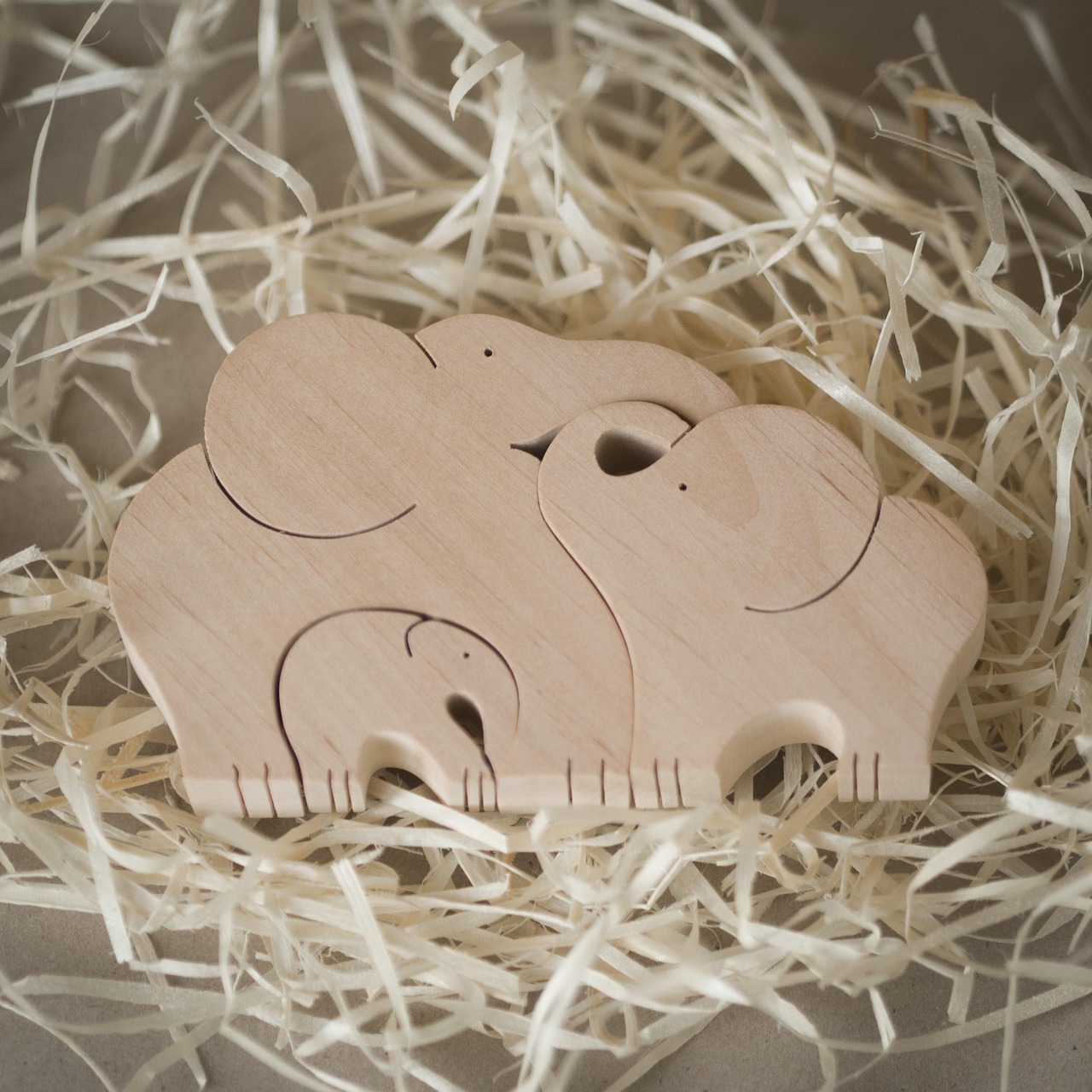 un adorno de madera que son tres elefantes enlazados entre sí