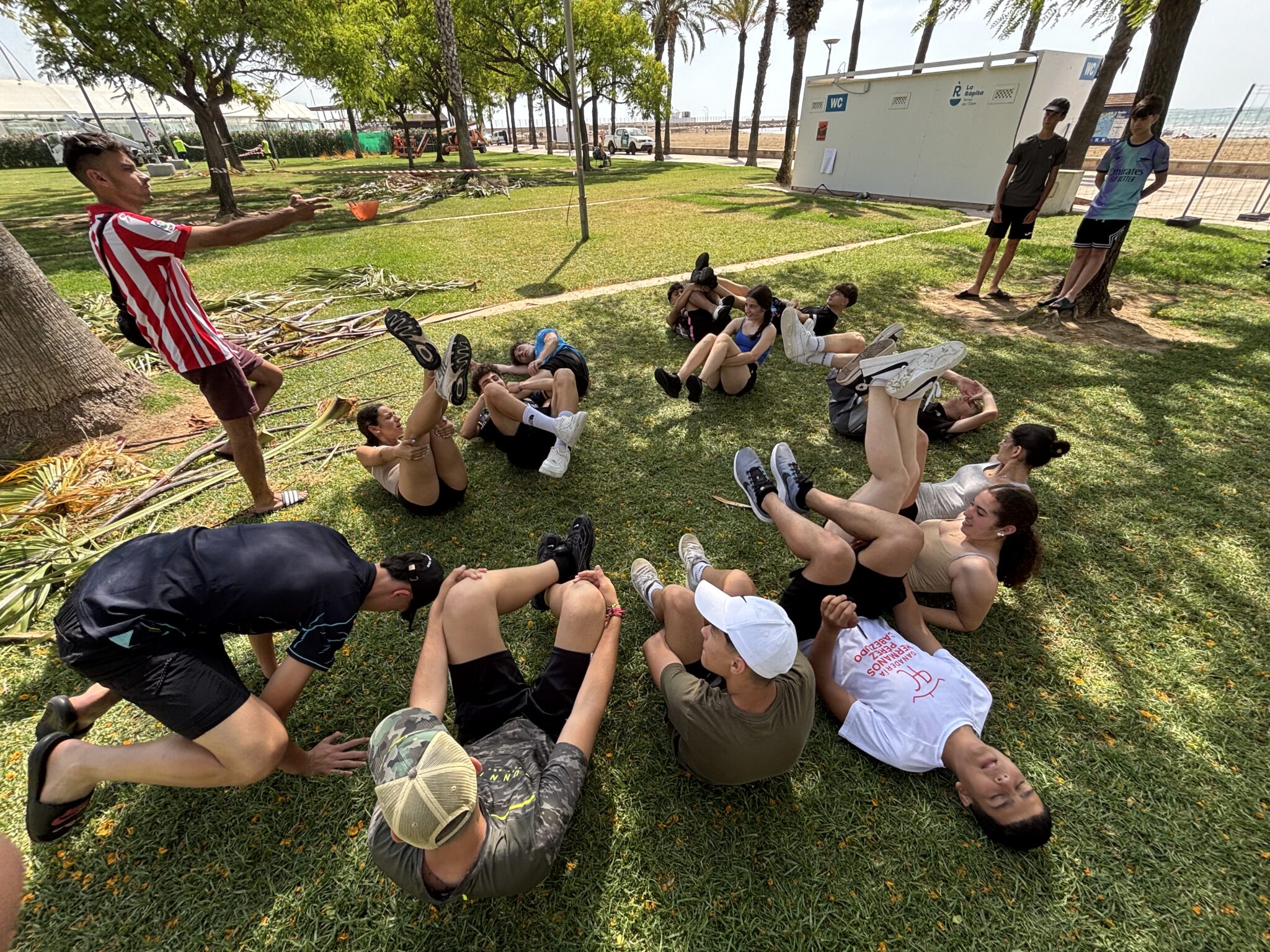 grupo de secundaria jugando en un parque donde uno de ellos dirige la actividad