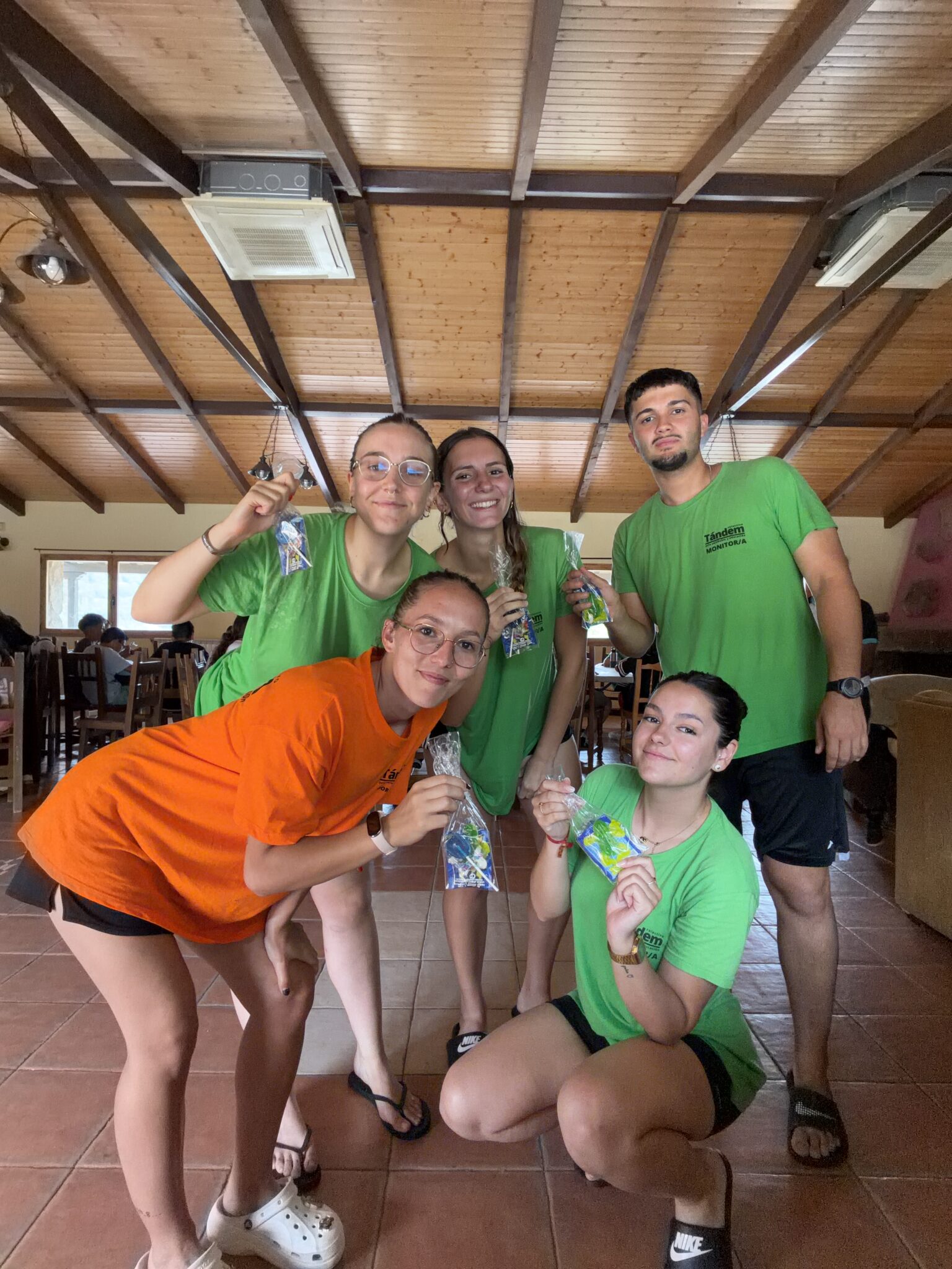 equipo de cuatro monitores y la coordinadora con sus camisetas corporativas dentro de un albergue