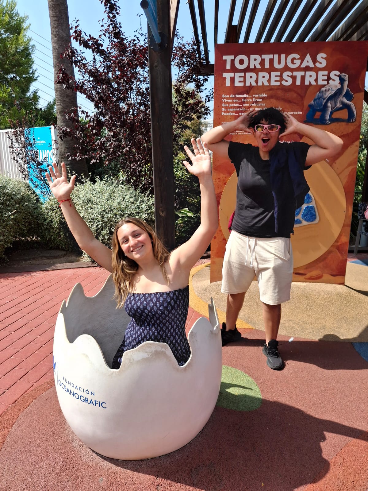 dos adolescentes jugando con un huevo de tortuga falso en el oceanografic