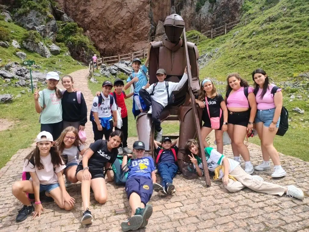 grupo de primaria en un viaje con una estatua en los lagos de covadonga