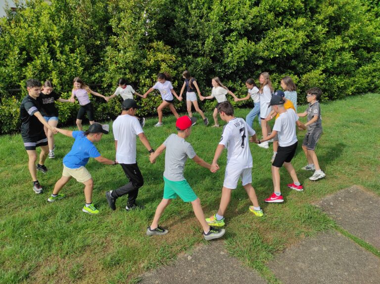 Grupo de primaria en circulo y con las manos cogidas