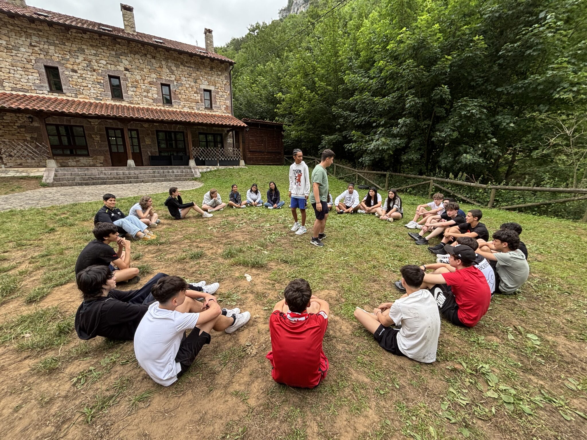 grupo de secundaria sentado en la hierba realizando un juego