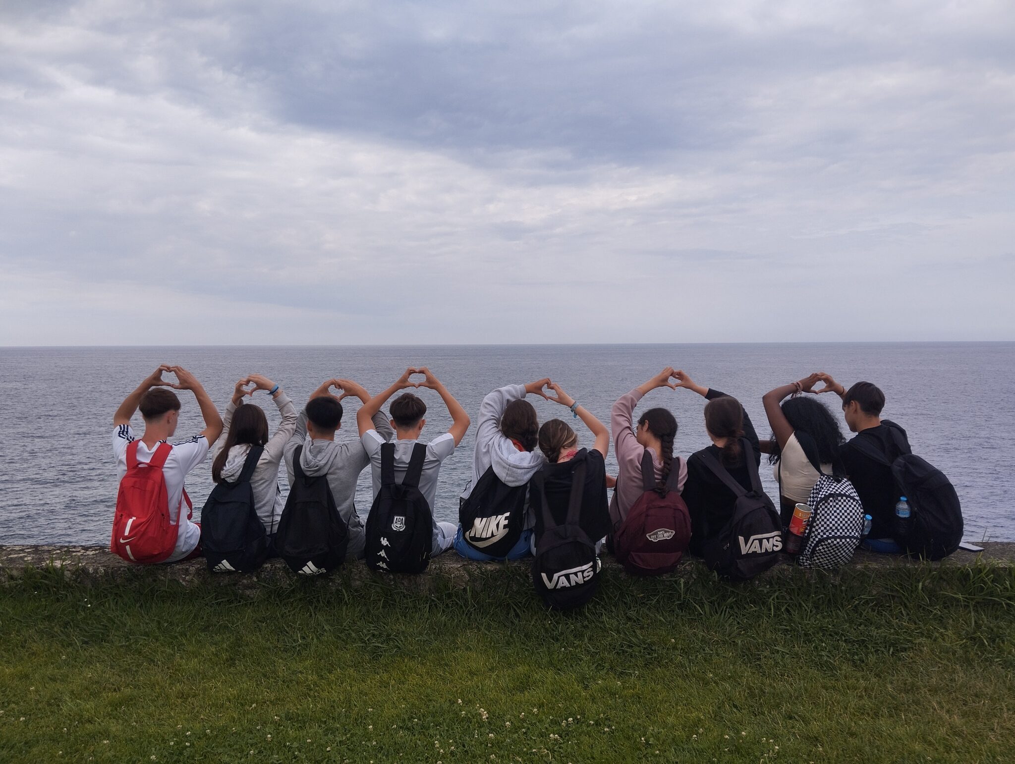 grupo de primaria de espalda con las manos en forma de corazón y el fondo de mar
