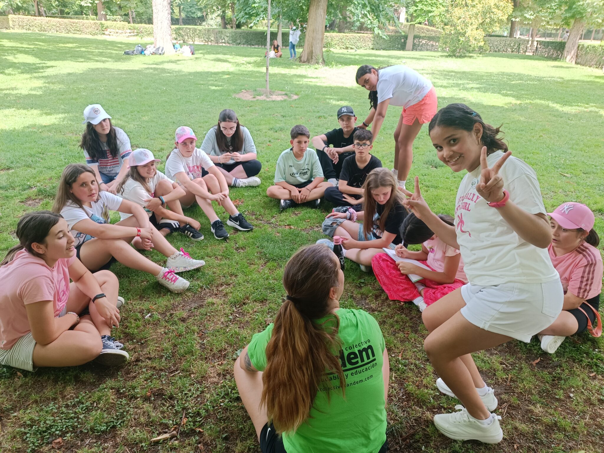 grupo de primaria en un viaje de fin de curso en circulo sentado en el suelo con su monitora