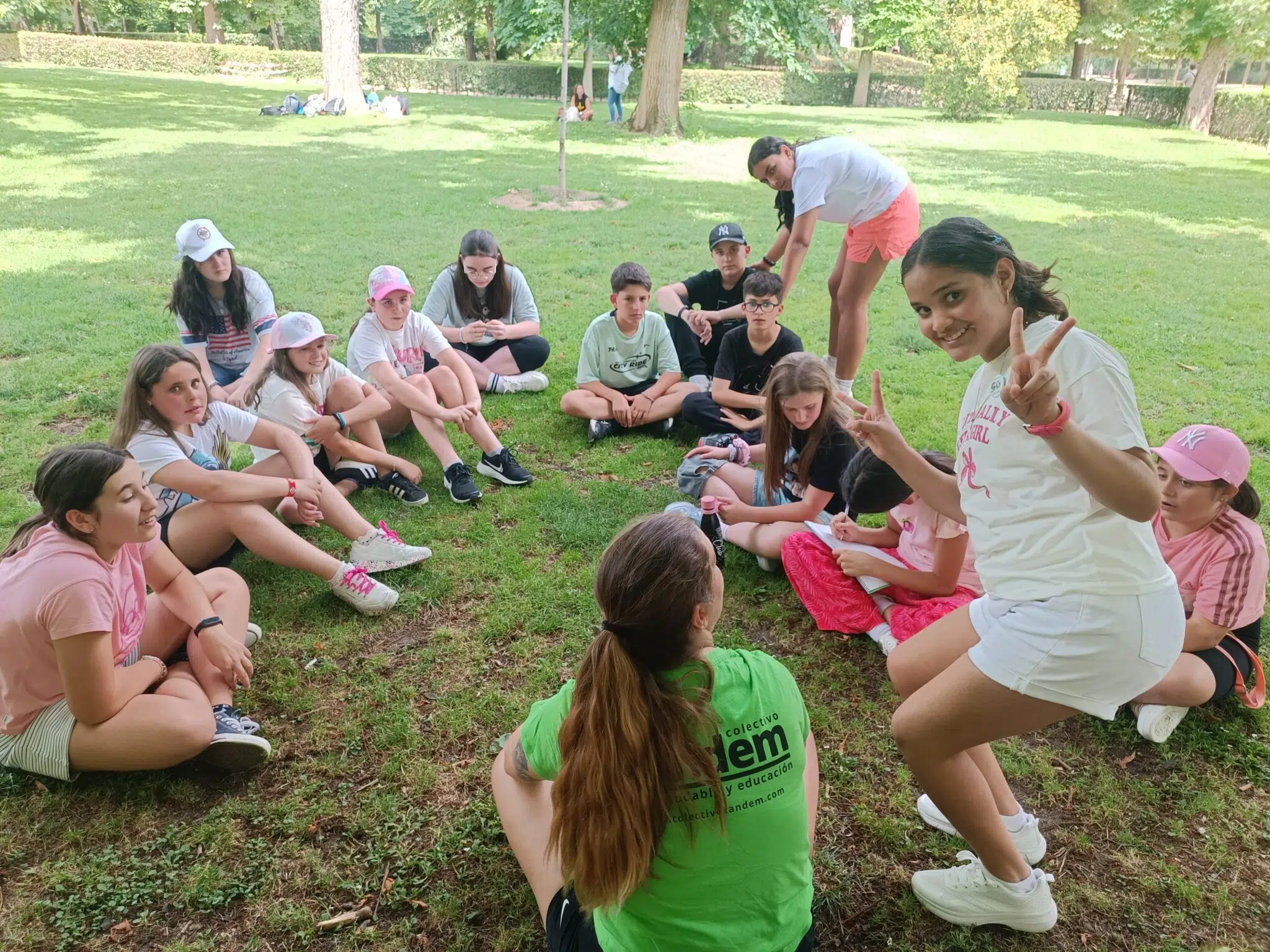 grupo de primaria en un viaje de fin de curso en circulo sentado en el suelo con su monitora