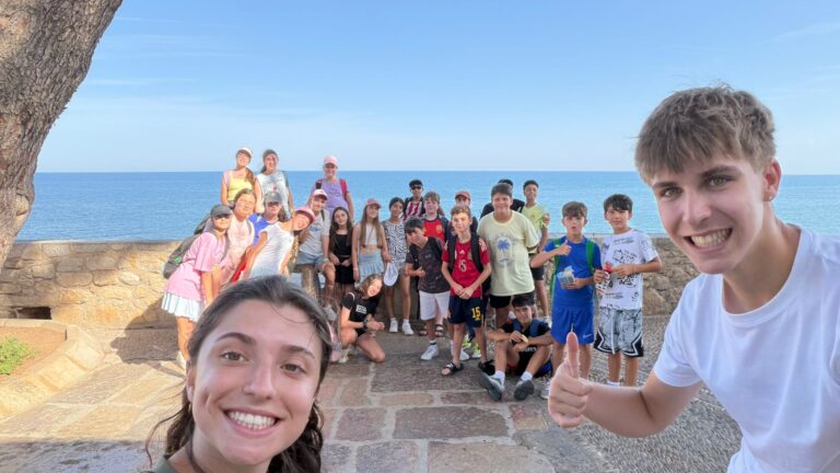 Grupo de primaria con sus monitores sonrientes en primer plano en un mirador al mar