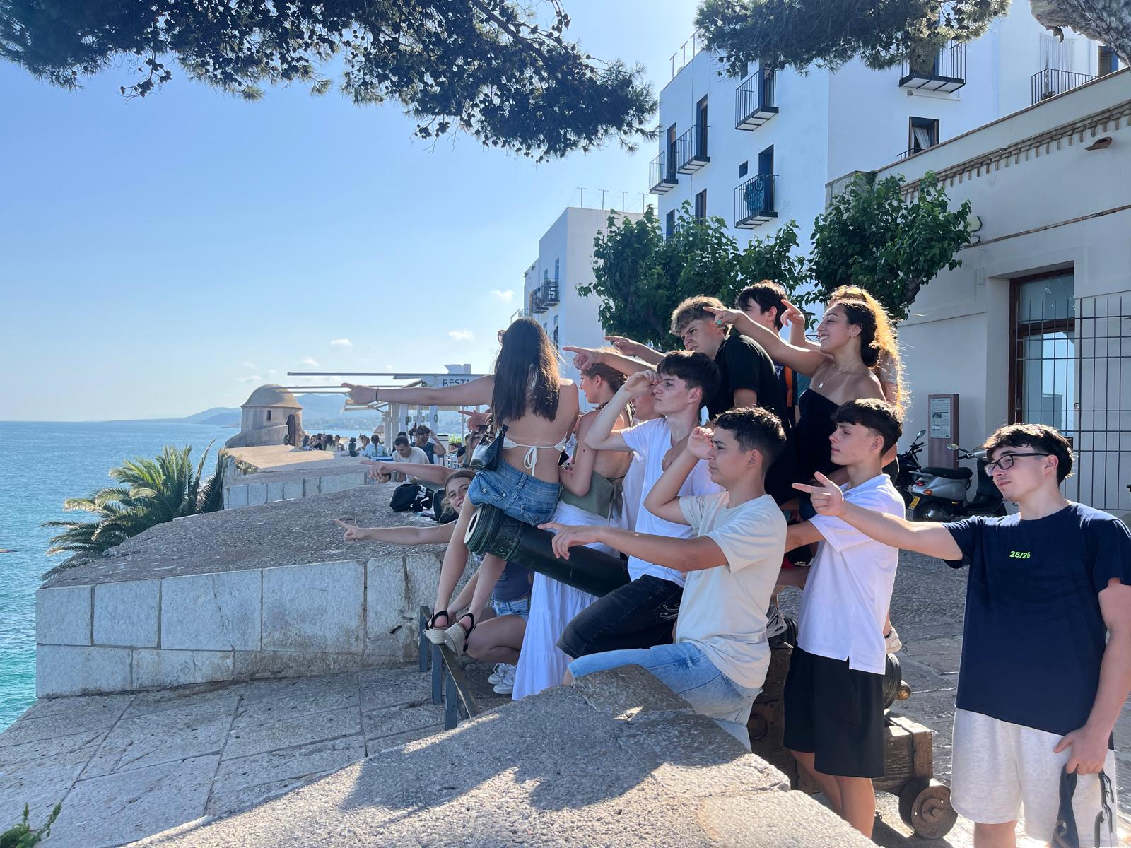 grupo de chavales en un mirador al mar apuntando todos a un lugar