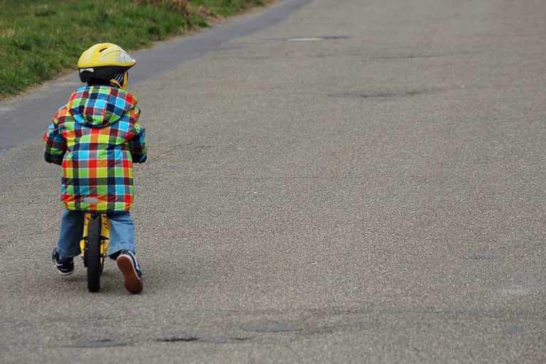niño pequeño montado en bicicleta visto de espaldas