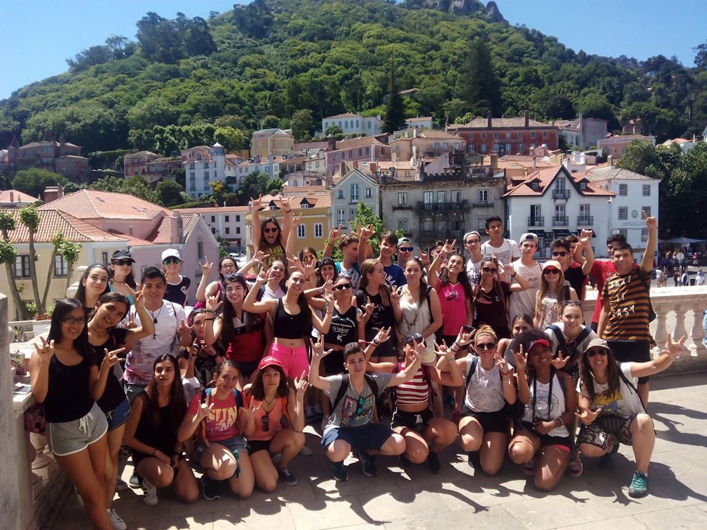 grupo de estudiantes de fondo se ve un pueblo y una montaña boscosa