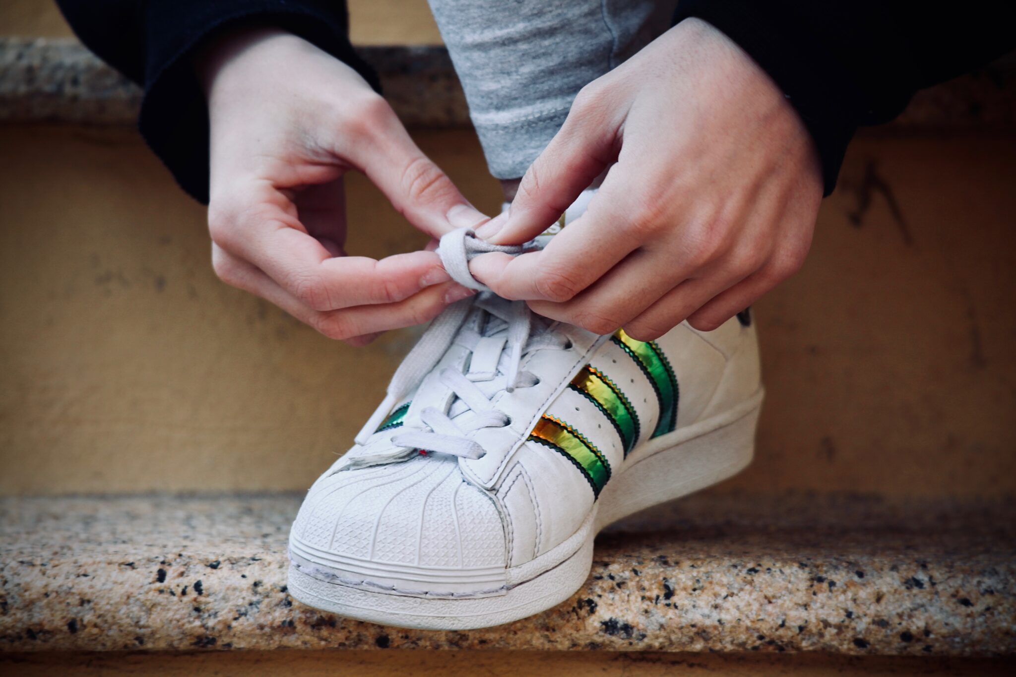 primer plano de unas manos atándose una deportiva blanca