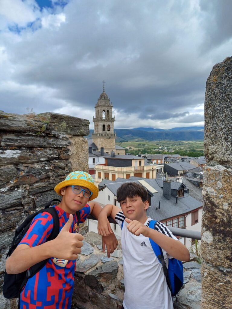 dos chicos uno con gorro y gafas, al fondo una iglesia