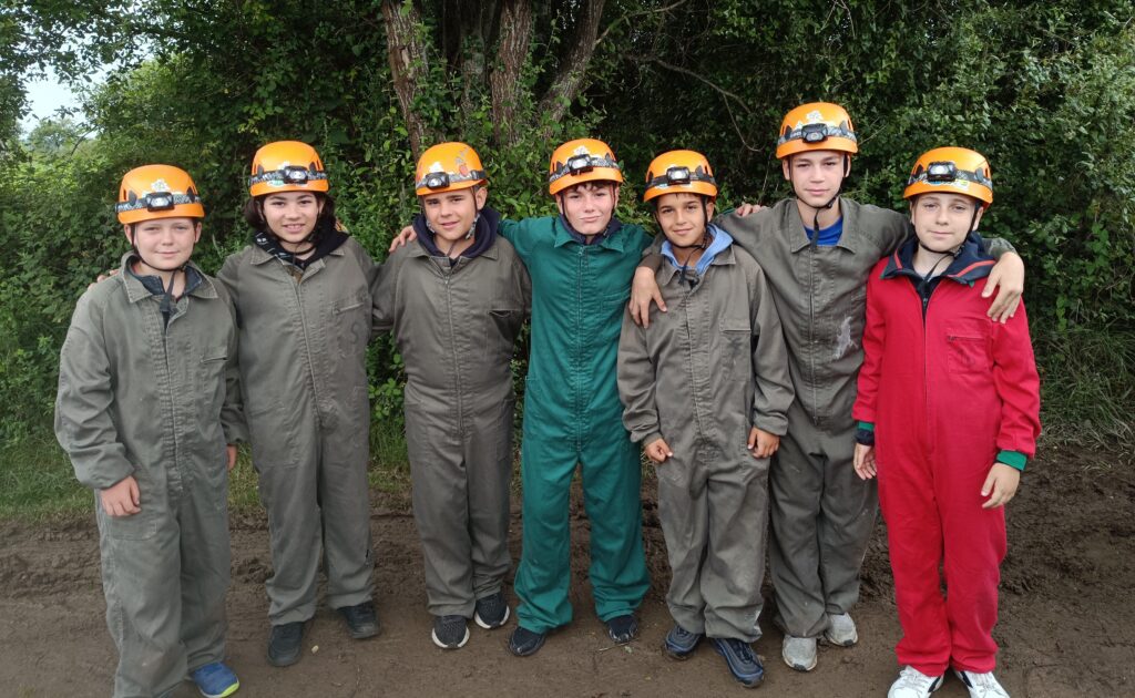 escolares vestidos con monos y cascos con frontal con luz