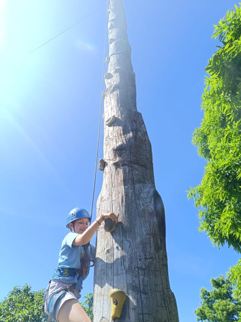 participante escalando con casco y arnés