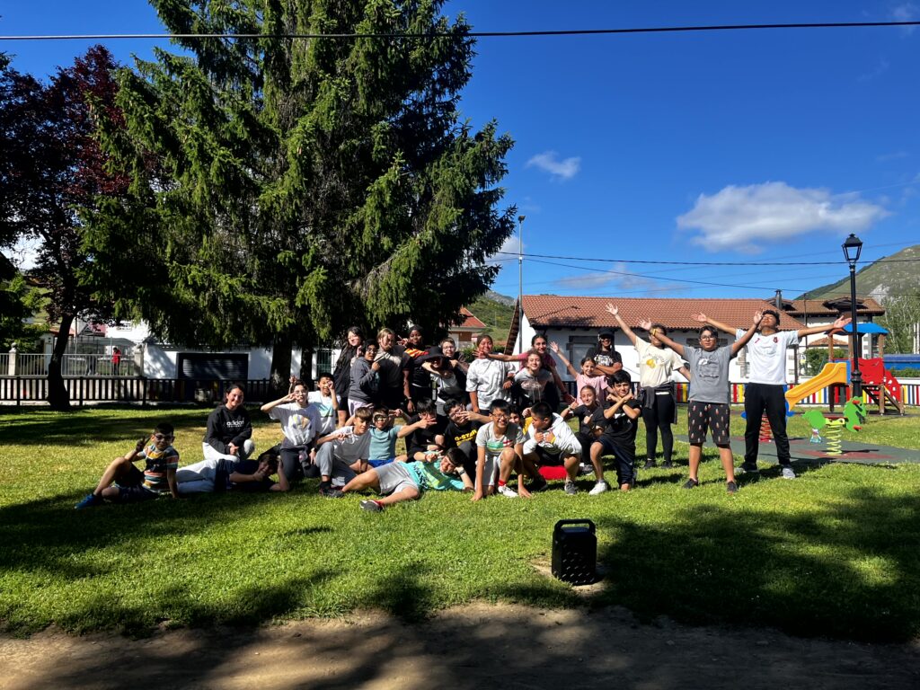 chicos y chicas de primaria en un parque algunos sentados y otros de pie