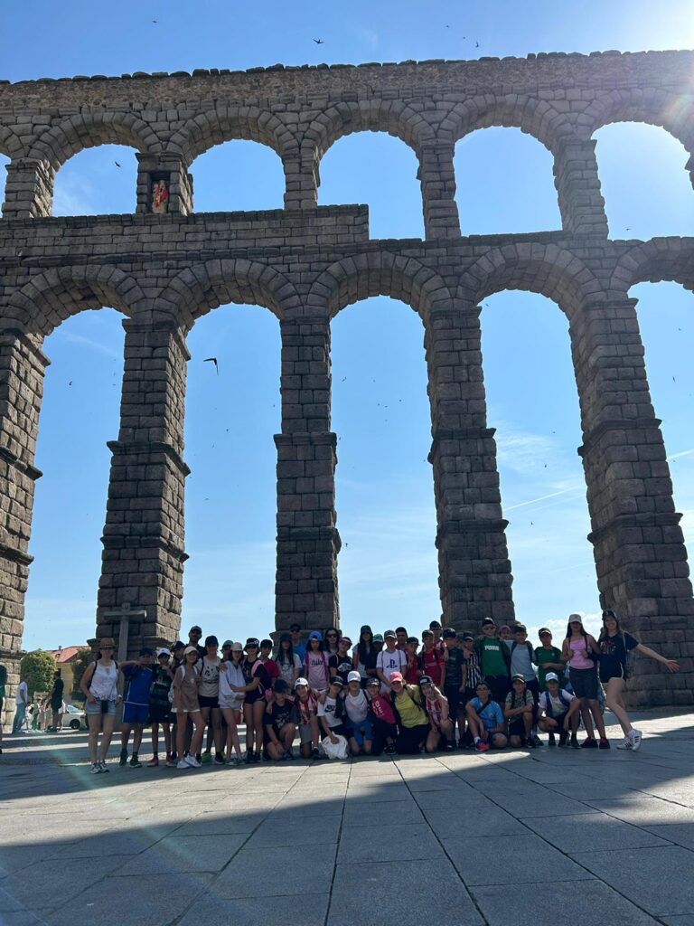 grupo de chavales a los pies del acueducto de Segovia en su viaje de fin de curso